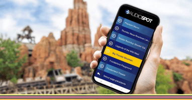 Mobile showing app with Disneyland in background