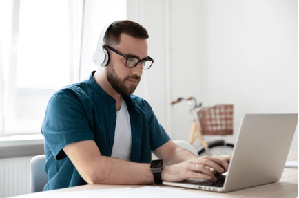 Male on his laptop transcribing